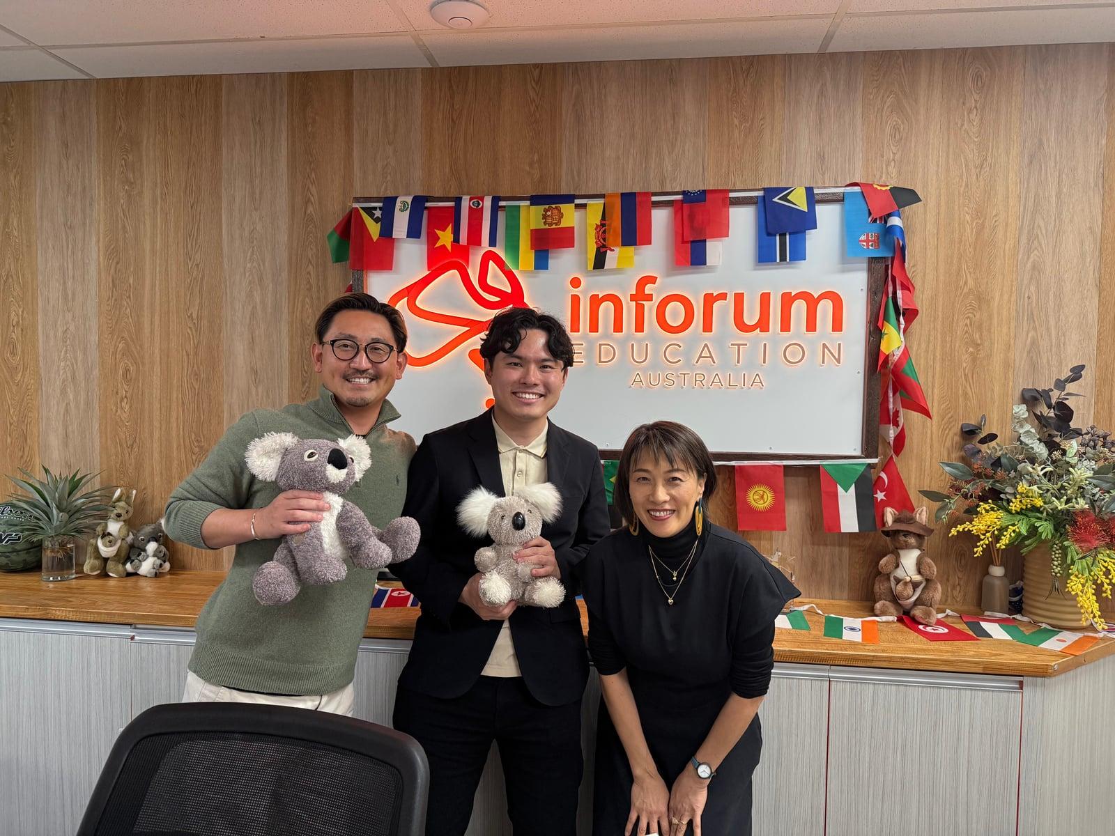 Inforum の受付前で、コアラのぬいぐるみを持った学校スタッフと成功する留学の代表が撮影した写真