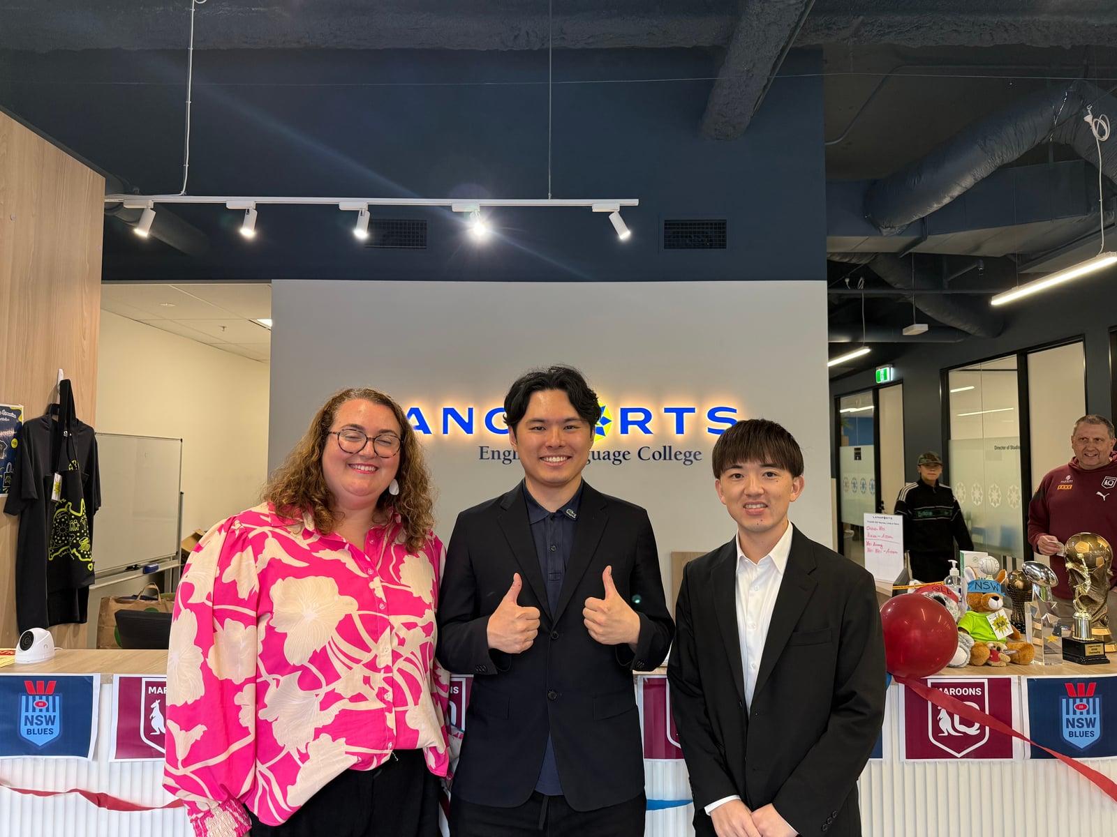 Langports ブリスベン校の受付前で、学校担当者と成功する留学の代表が撮影した写真